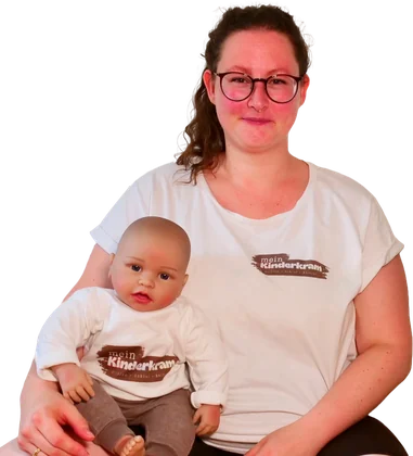 Laura Lottermann von mein Kinderkram mit einer Babypuppe auf dem Schoß